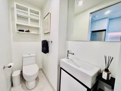 a white bathroom with a toilet and a sink at Luxurious studio downtown Montreal in Montréal