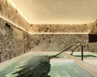 a large swimming pool in a stone walled bathroom at Luxurious studio downtown Montreal in Montréal