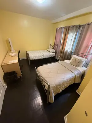 a room with two beds and a table at Private Room Not Entire Apt Steps DownTown 18Mins Airport in Montréal