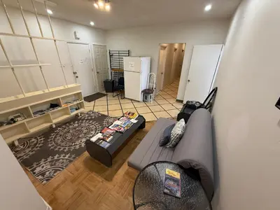 a living room with a couch and a refrigerator at Private Room Not Entire Apt Steps DownTown 18Mins Airport in Montréal