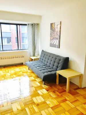 a living room with a blue couch and a wooden floor at Modern Apartment City Living in the Golden Square Mile in Montréal