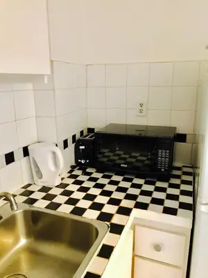 a kitchen with a sink and a black and white checkered floor at Modern Apartment City Living in the Golden Square Mile in Montréal