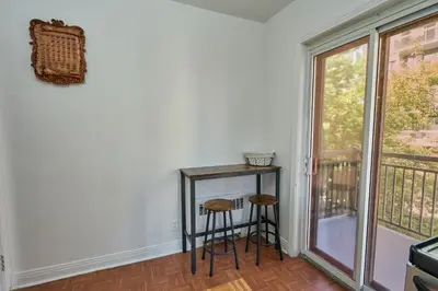 a room with a table and two stools next to a window at Van Horne Black VIP in Montréal