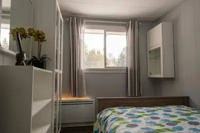 a small bedroom with a bed and a window at Spa Scandinave - Les Balancoires in Mansonville