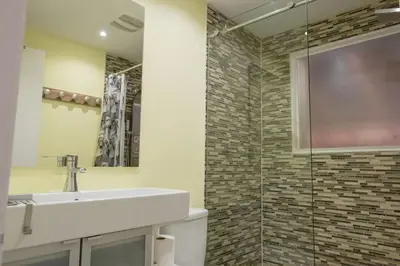 a bathroom with a sink and a glass shower at Spa Scandinave - Les Balancoires in Mansonville