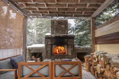 a fireplace in a patio with a couch and a table at Spa Scandinave - Les Balancoires in Mansonville