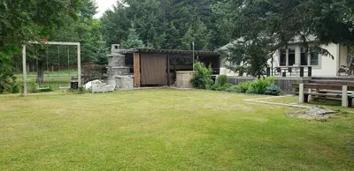 a large yard with a house and a goal at Spa Scandinave - Les Balancoires in Mansonville
