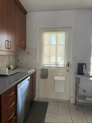 a kitchen with a white door and a window at Cozy 1 bdrm apartment in the Village in Montréal