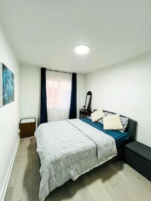 a bedroom with a large bed and a couch at Baraqah Residence Gorgeous New 5BD Home 15mins-MTL in Longueuil