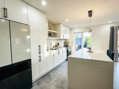 a kitchen with white cabinets and a large island at Baraqah Residence Gorgeous New 5BD Home 15mins-MTL in Longueuil
