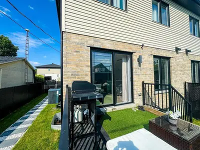 a barbecue grill in the yard of a house at Baraqah Residence Gorgeous New 5BD Home 15mins-MTL in Longueuil