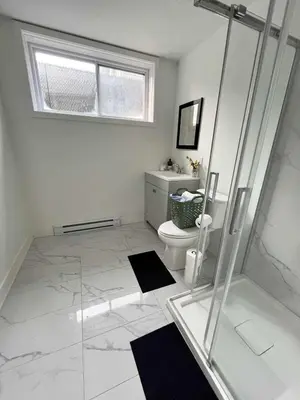 a bathroom with a glass shower and a toilet at Baraqah Residence Gorgeous New 5BD Home 15mins-MTL in Longueuil
