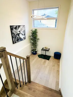 a room with a staircase with a potted plant and a window at Baraqah Residence Gorgeous New 5BD Home 15mins-MTL in Longueuil