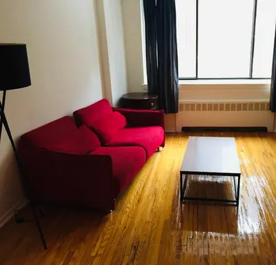 a living room with a red couch and a table at Modern City Studio Living in the Golden Square Mile in Montréal