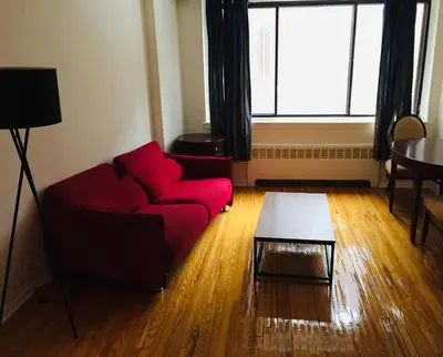 a living room with a red couch and a table at Modern City Studio Living in the Golden Square Mile in Montréal