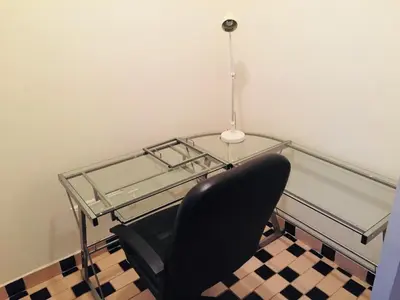 a glass table with a black chair and a lamp at Modern City Studio Living in the Golden Square Mile in Montréal