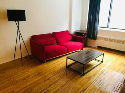 a red couch in a living room with a coffee table at Modern City Studio Living in the Golden Square Mile in Montréal