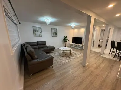 a living room with a couch and a television at Private Basement Suite in Laval in Laval