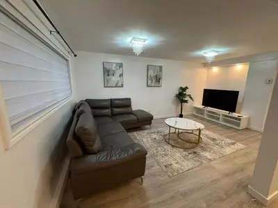 a living room with a couch and a television at Private Basement Suite in Laval in Laval