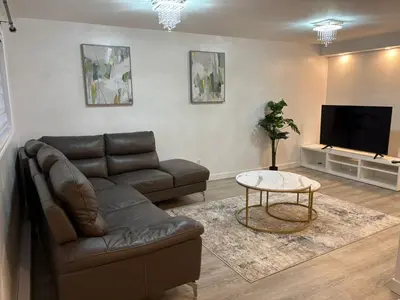 a living room with a couch and a tv at Private Basement Suite in Laval in Laval