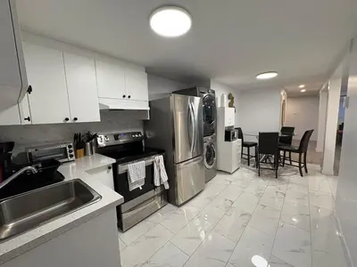 a kitchen with stainless steel appliances and a table at Private Basement Suite in Laval in Laval