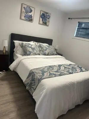 a bedroom with a large bed with a white comforter at Private Basement Suite in Laval in Laval
