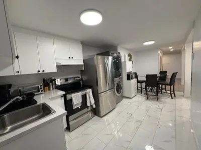 a kitchen with stainless steel appliances and a table at Private Basement Suite in Laval in Laval