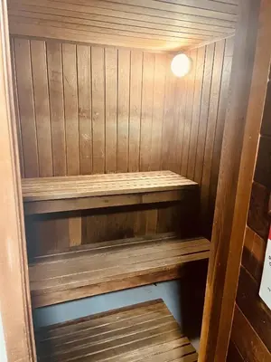 a sauna with wooden shelves in a room at Lumineux condo au bord du lac in Magog-Orford