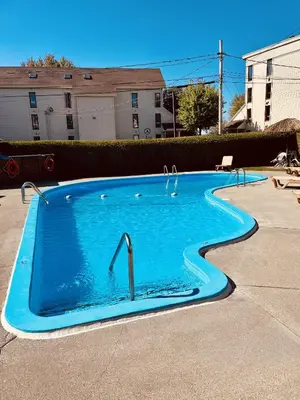 a large blue swimming pool with a faucet at Lumineux condo au bord du lac in Magog-Orford