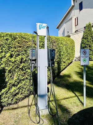 a gas pump with a sign on top of it at Lumineux condo au bord du lac in Magog-Orford