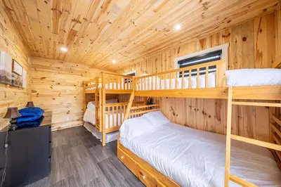 a bedroom with two bunk beds in a log cabin at Nature Spa & Lake Access - Le Maikel in Beauceville-Est