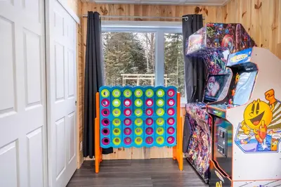 a room with a game machine next to a door at Nature Spa & Lake Access - Le Maikel in Beauceville-Est