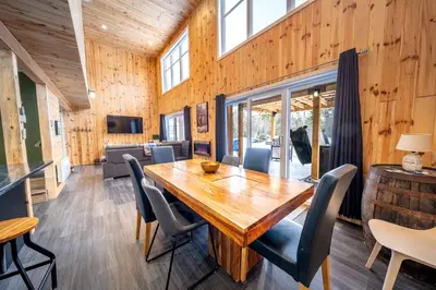 a dining room with a wooden table and chairs at Nature Spa & Lake Access - Le Maikel in Beauceville-Est