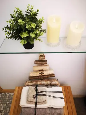 a shelf with a stack of towels and candles at Private Hummingbird Room - Modern & Cozy in Mansonville