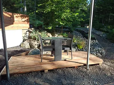 a table and chairs sitting on a wooden deck at Private Hummingbird Room - Modern & Cozy in Mansonville