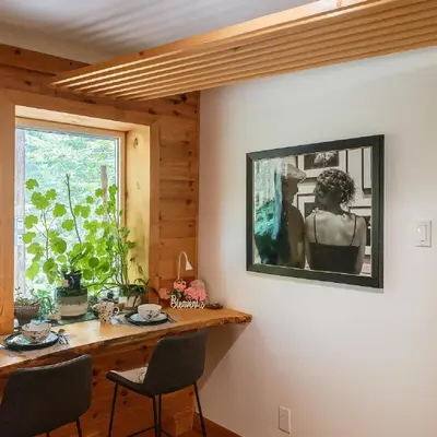 a dining room table with chairs and a picture on the wall at Private Hummingbird Room - Modern & Cozy in Mansonville