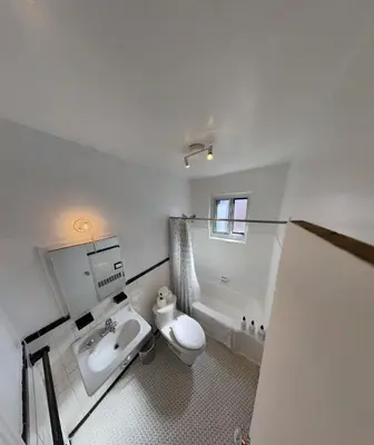 a white bathroom with a sink and a toilet at Van Horne Sweet Celebration in Montréal
