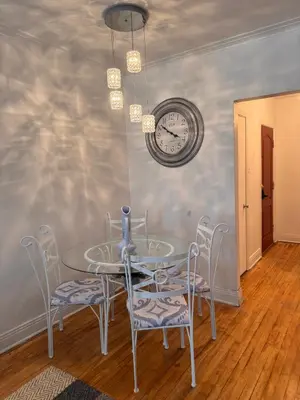 a dining room with a table and chairs and a clock at Van Horne Sweet Celebration in Montréal