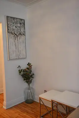 a room with a table and a vase with a plant at Van Horne Sweet Celebration in Montréal