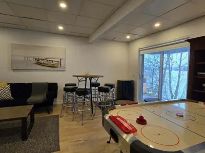 a living room with a ping pong table and chairs at Lakefront Spa - Chez Bernard L'Hermite in St-Ferdinand