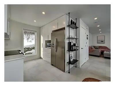 a kitchen with a stainless steel refrigerator in a room at Lakefront Spa - Chez Bernard L'Hermite in St-Ferdinand