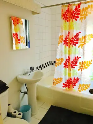 a bathroom with a sink and a shower curtain at Modern City Studio Living in the Golden Square Mile in Montréal
