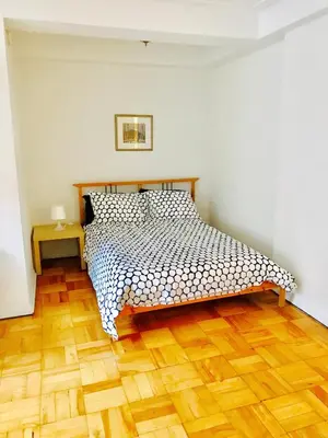 a bedroom with a bed and a wooden floor at Modern City Studio Living in the Golden Square Mile in Montréal