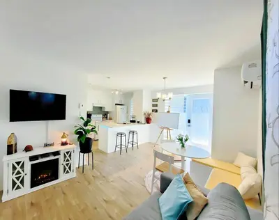 a living room with a couch and a table with a fireplace at MTR Apart Montreal Hospital Corporate Stay in Longueuil