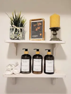 a shelf with four bottles of soap and a lamp at MTR Apart Montreal Hospital Corporate Stay in Longueuil