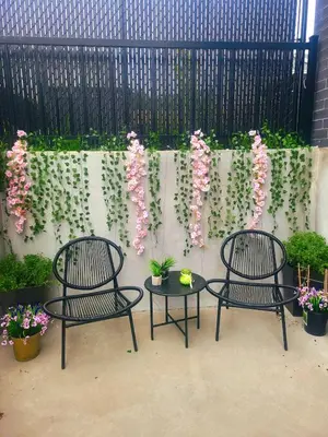 two chairs and a table with flowers on a fence at MTR Apart Montreal Hospital Corporate Stay in Longueuil