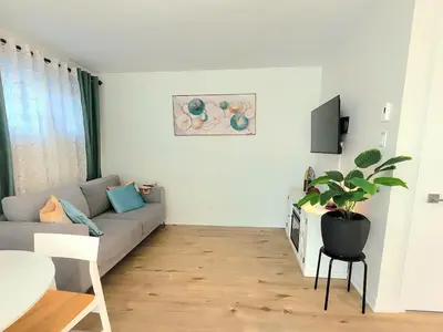 a living room with a couch and a potted plant at MTR Apart Montreal Hospital Corporate Stay in Longueuil