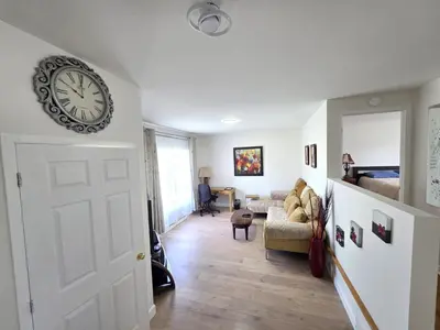 a living room with a clock on the wall at Warm Welcome Home in Longueuil