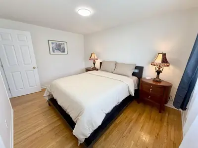 a bedroom with a bed and two lamps on a table at Warm Welcome Home in Longueuil