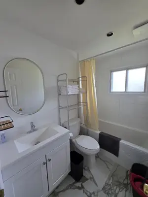 a bathroom with a sink and a toilet and a mirror at Warm Welcome Home in Longueuil
